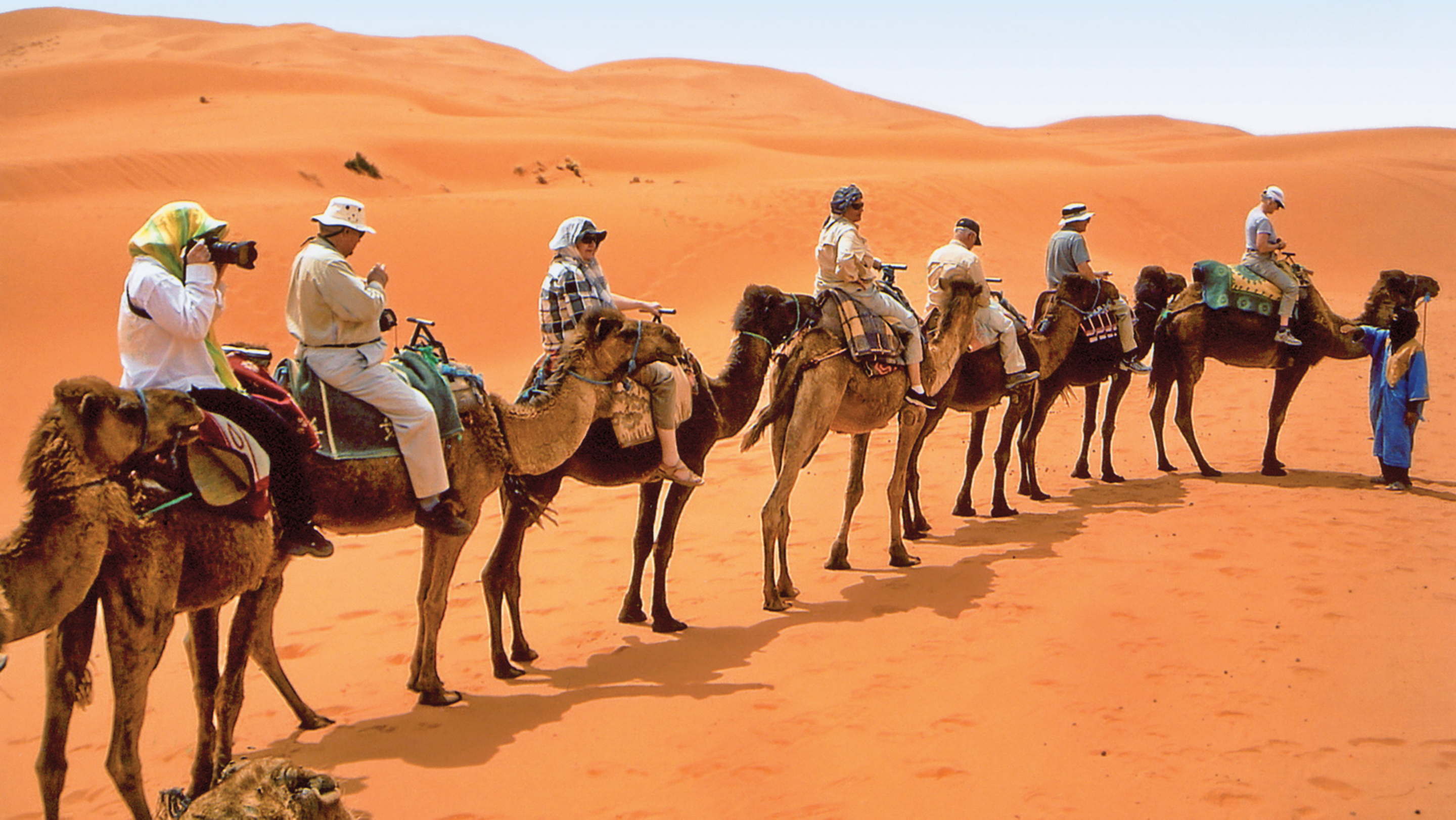 Small group travelers set out on camel back in the desert
