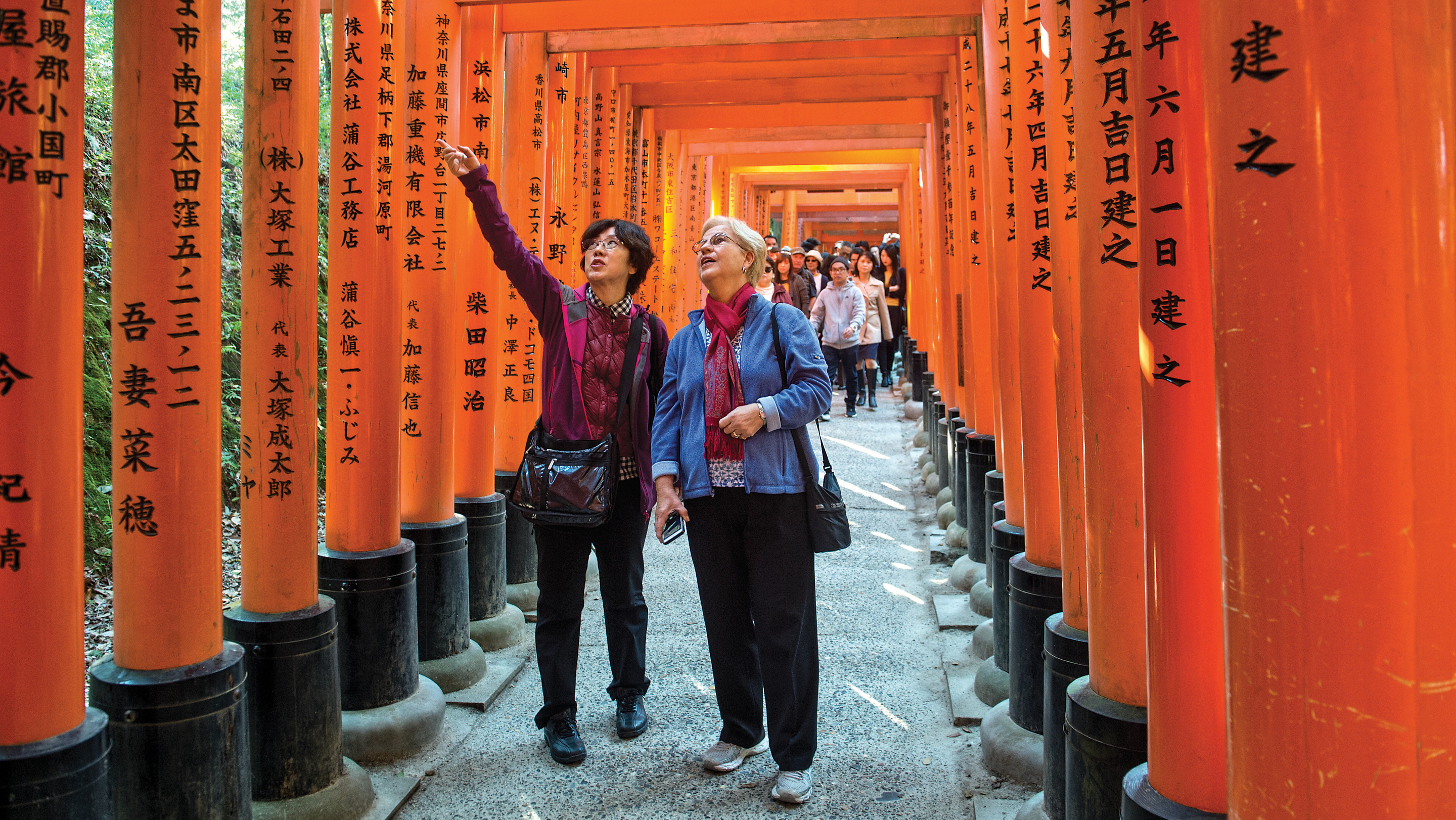 A Trip Experience Leader shows a solo female traveler a location in Asia